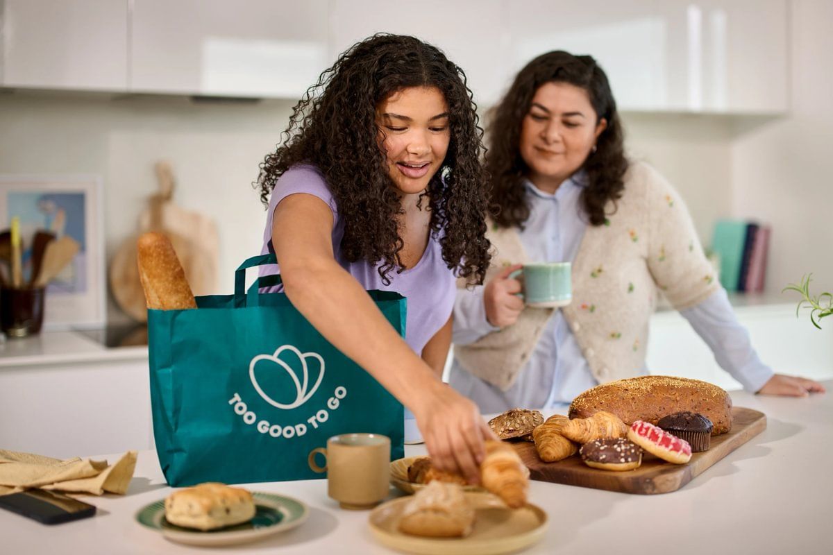 two women are standing in a kitchen preparing food .