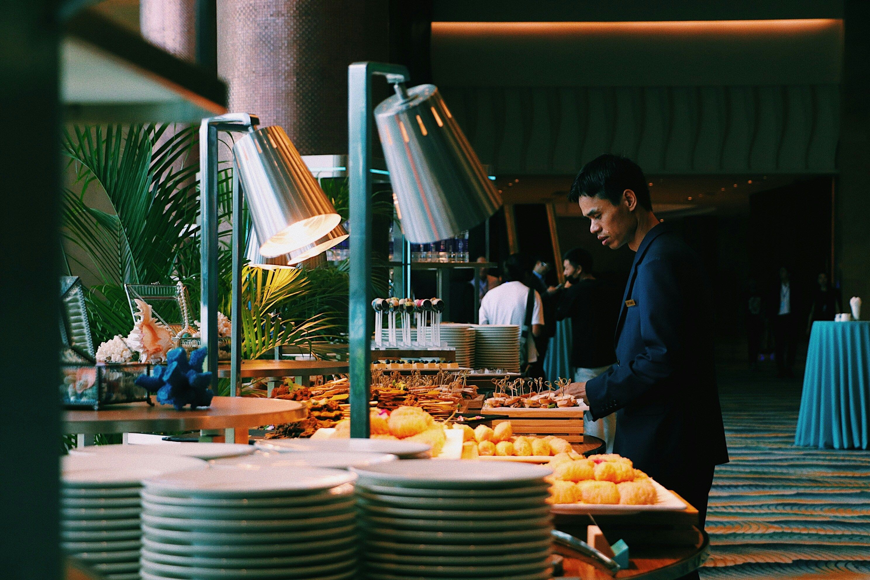 a man is standing in front of a buffet table with plates of food