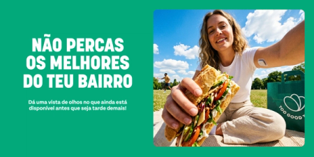 A smiling woman holds a large sandwich in a park with a 'Too Good To Go' bag. Text on a green background reads: 'NÃO PERCAS OS MELHORES DO TEU BAIRRO. Dá uma vista de olhos no que ainda está disponível antes que seja tarde demais!'