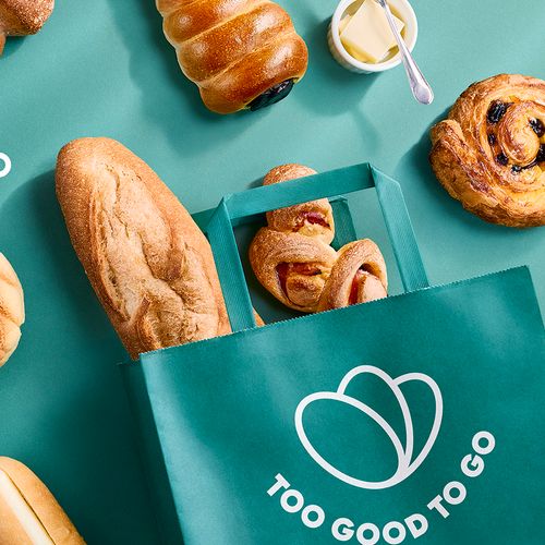 Assorted bread and pastries are displayed on a teal background, with some in a green "Too Good To Go" bag. Japanese text and a ¥798 price tag are visible.