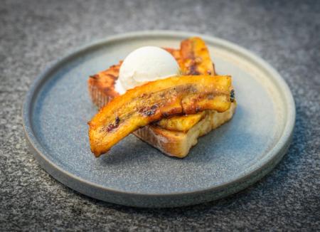 French toast topped with caramelized bananas and a scoop of ice cream.