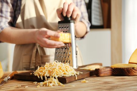 a person is cracking an egg into a carton of eggs .