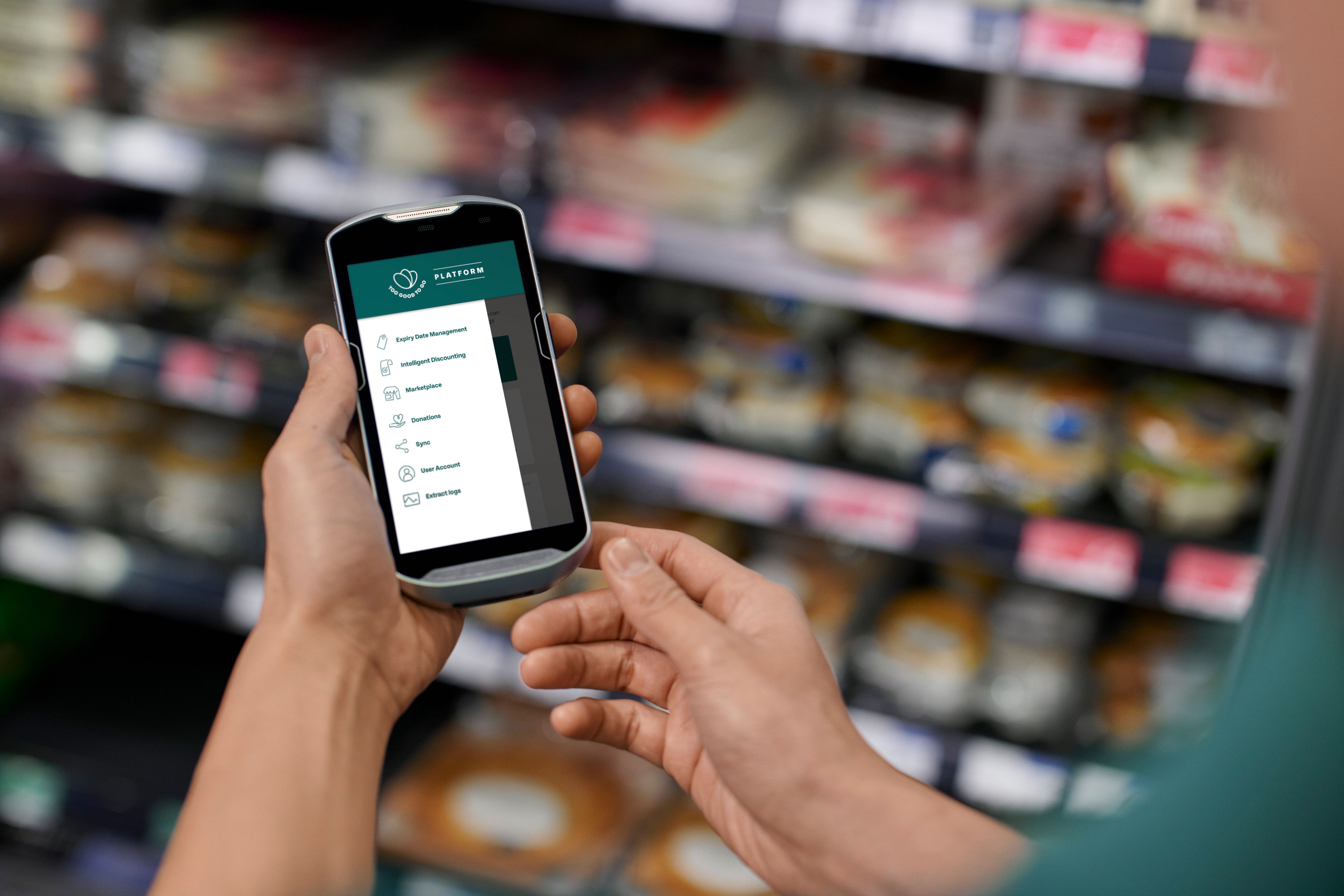 a person is holding a cell phone in a grocery store .
