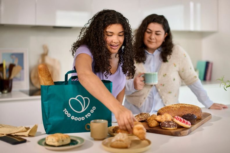 two women are standing in a kitchen preparing food .