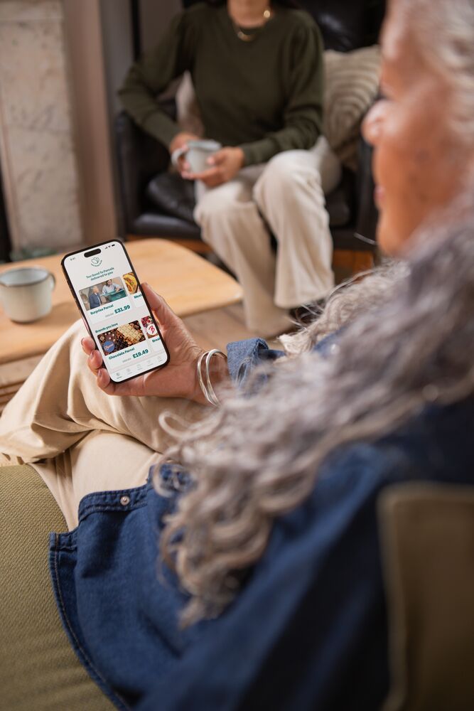 a woman is sitting on a couch looking at her phone .