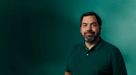 a man with a beard wearing a green polo shirt is standing in front of a green wall .
