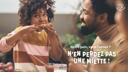 a little girl is eating a piece of toast next to a man and the words notre pain vous l' aimez