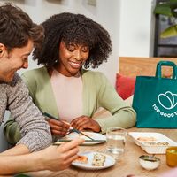 a woman is holding a green bag that says good to go