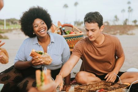 a group of people are having a picnic on the beach .