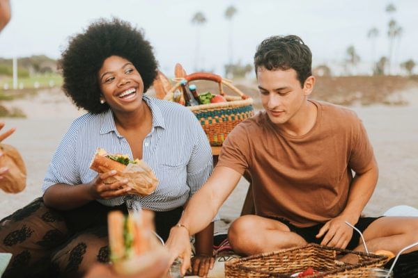 a group of people are having a picnic on the beach .