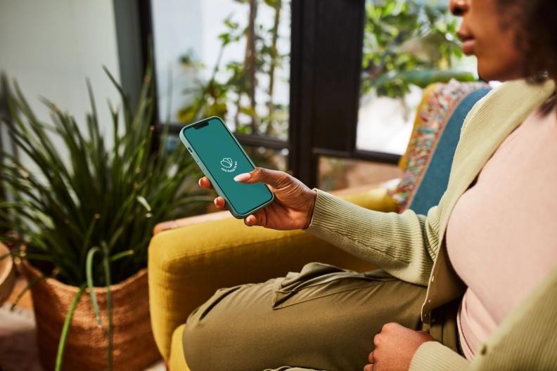 a woman is sitting in a chair holding a cell phone .