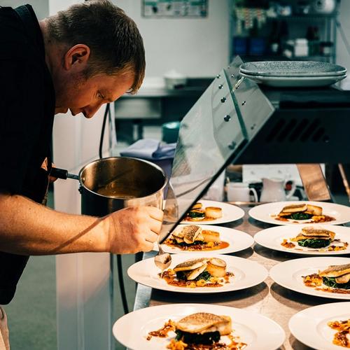a man is preparing food in a professional kitchen