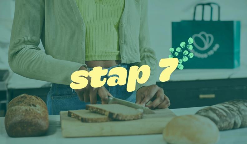 a woman is cutting bread on a cutting board in a kitchen .