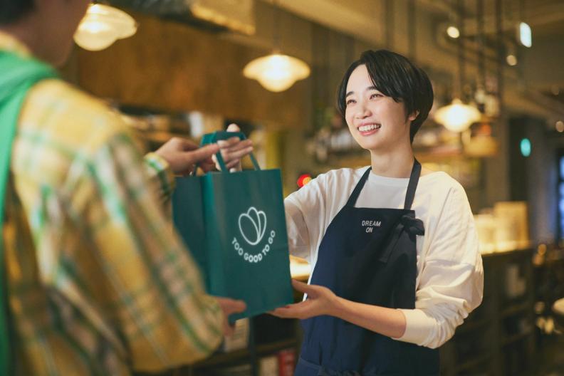 Man smiling behind a bakery counter