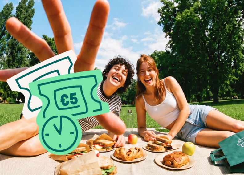 Two laughing friends picnic in a sunny park with food, a hand making a peace sign is above them, and overlaid cartoon €5 discount tickets with a timer icon are visible.