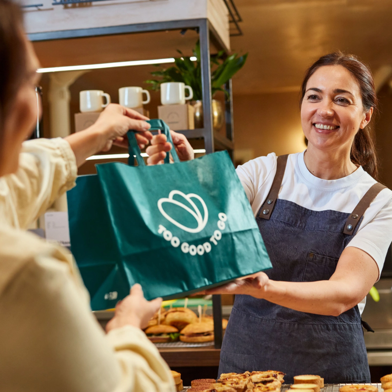 Woman giving a TGTG surprise bag