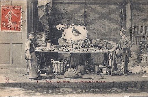 Vintage photo of a shellfish vendor and two men at a market stall in Les Halles, Paris.