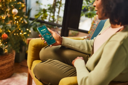 a woman is sitting in a chair holding a phone that says ' swipe ' on the screen