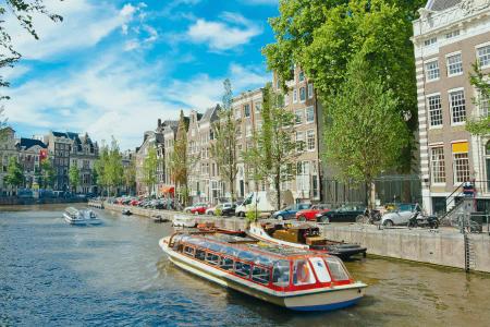 a boat is floating down a canal in amsterdam .