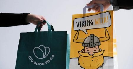 a person is holding a bag with a picture of a viking on it .