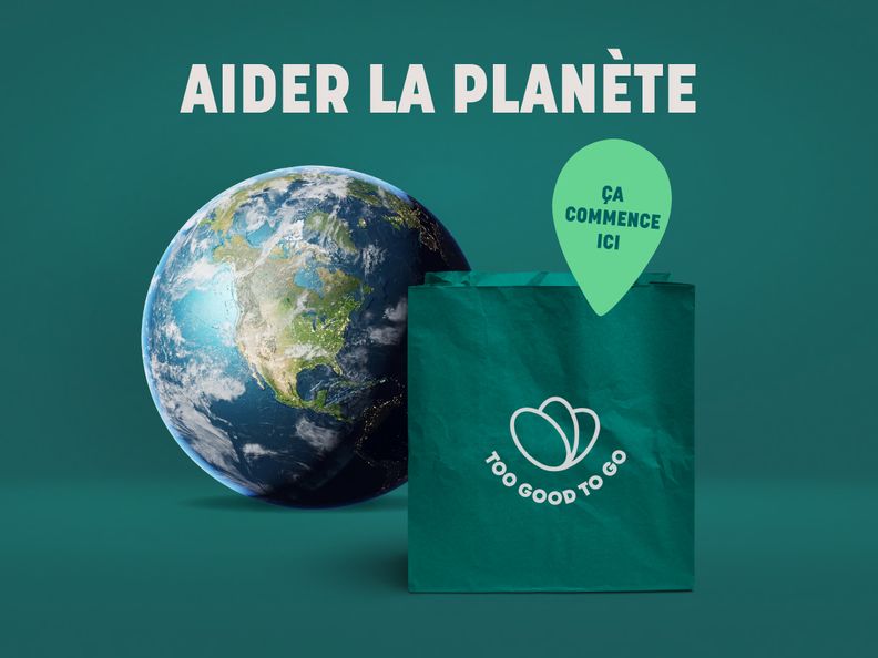 a green bag with a heart on it is sitting next to a globe .