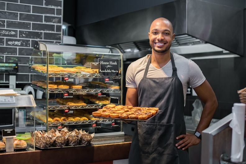 Baker holding a tray of baked goods