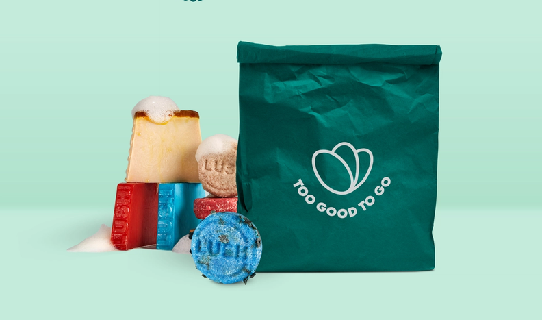 a green bag that says too good to go on it with Lush products next to it.
