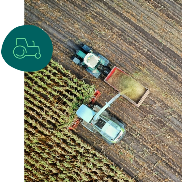 an aerial view of two tractors working in a field