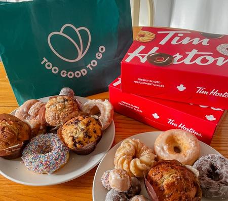 a bag that says too good to go is next to a box of tim hortons