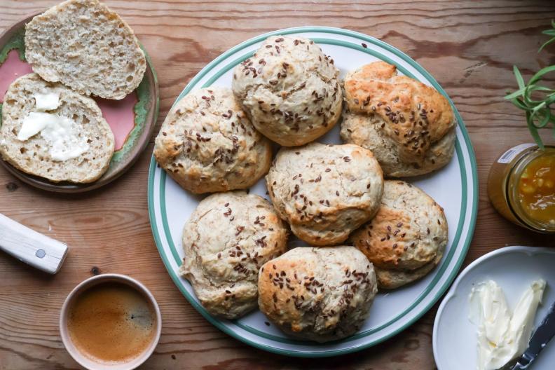 a plate of biscuits and a cup of coffee on a wooden table .