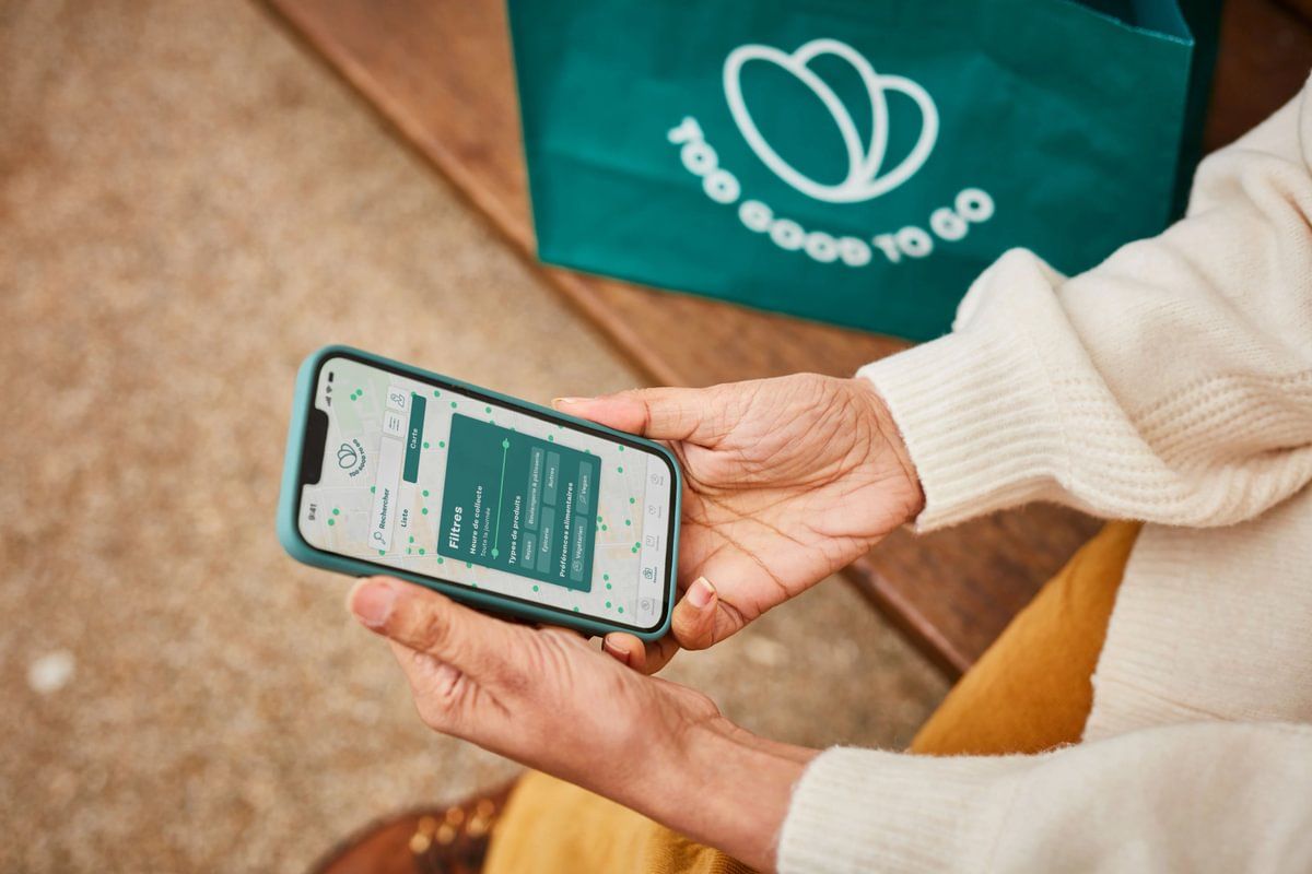 A food business owner handing over a too good to go bag