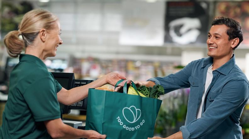 Customers eating pizza from a Too Good To Go bag