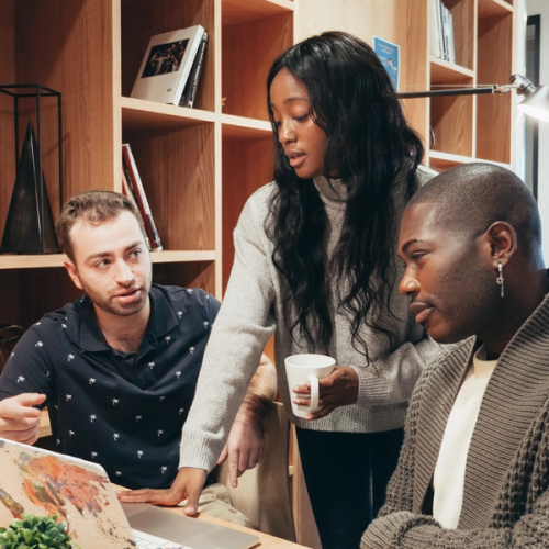 a group of people are looking at a laptop together