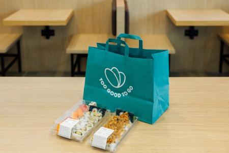 a blue bag filled with sushi is sitting on a wooden table .