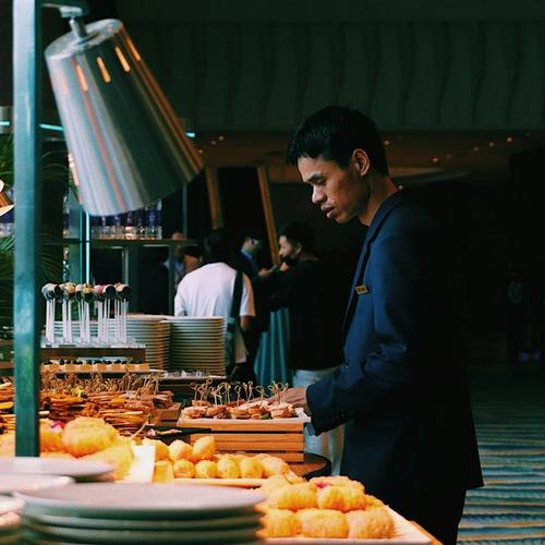 a man is standing in front of a buffet table with plates of food