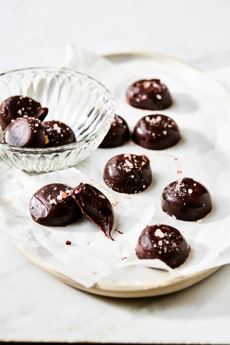 a plate of chocolates with a bite taken out of one of them