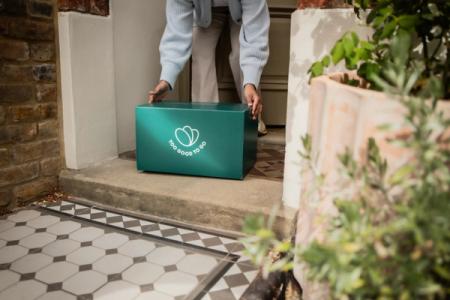 a person is putting a box on the doorstep of a house .