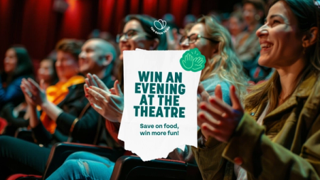 a group of people clapping in a theater with a sign that says win an evening at the theatre