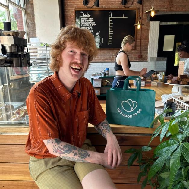 a man with tattoos is sitting at a counter in a restaurant .