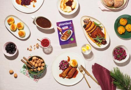 a table topped with plates of food and a box of planted meat .