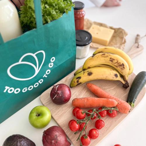 a green too good to go bag filled with fruits and vegetables