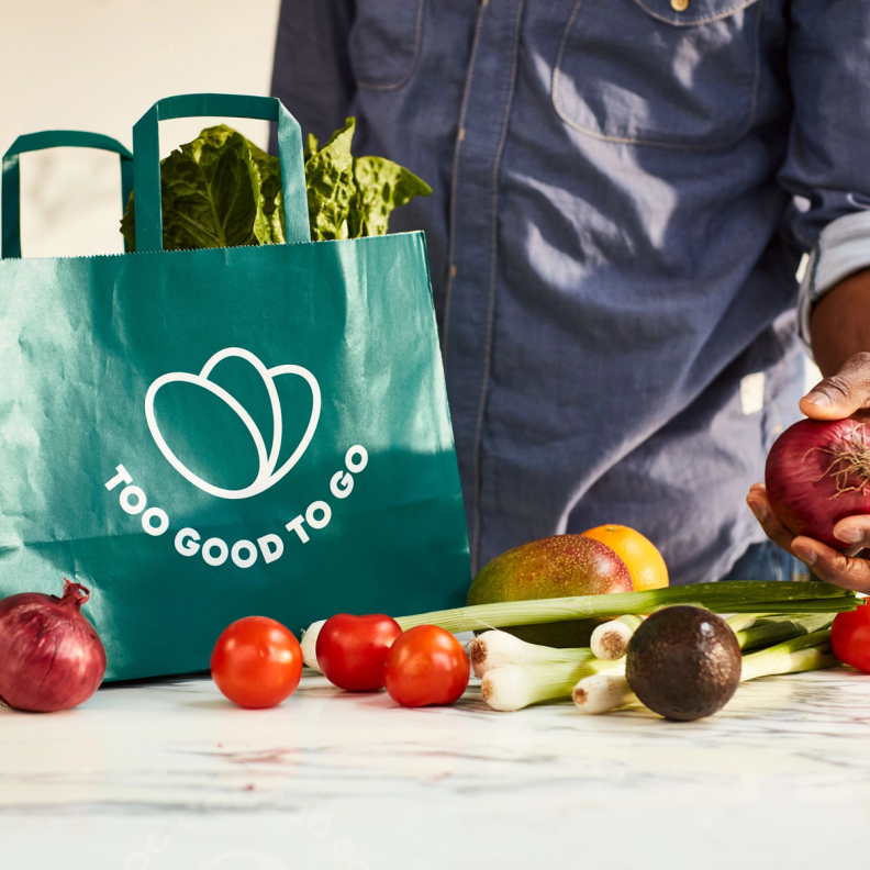 Hand picking up vegetables from a counter that has vegetables on