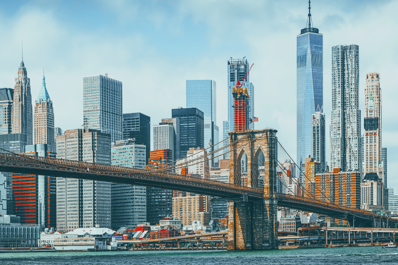 a bridge over a body of water with a city skyline in the background