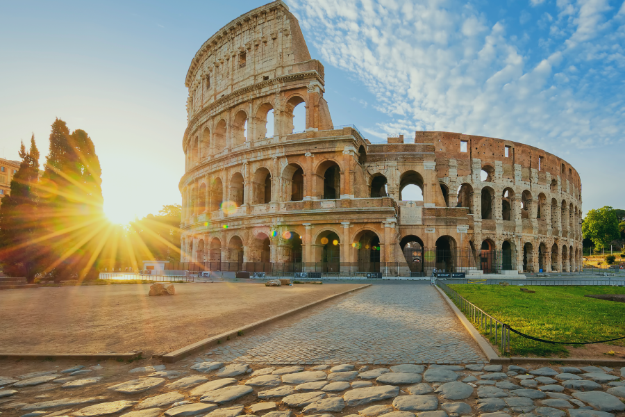 the sun shines brightly behind the colosseum in rome