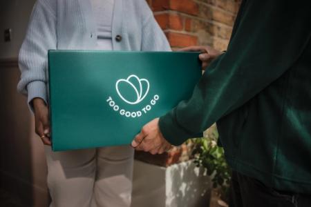 a person is handing a box to another person .