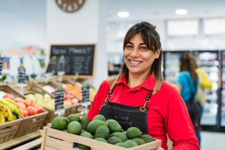 Smiling employee holding fresh produce