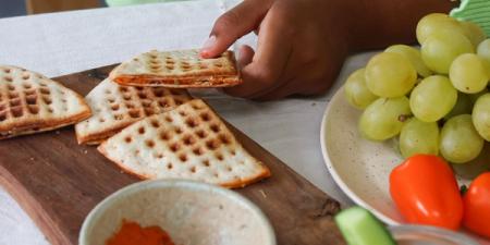 a tortilla is cut in half on a wooden cutting board