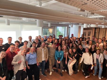 a large group of people are posing for a picture in a room .