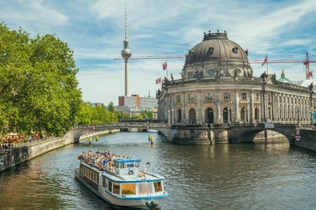 a boat is going down a river in front of a large building