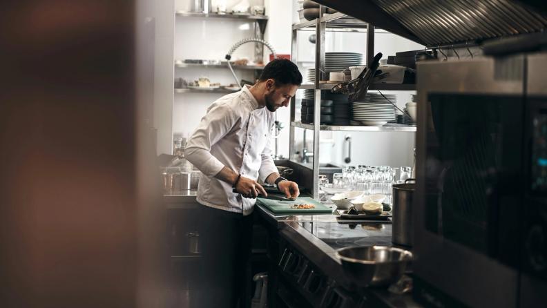 a cook preparing a dish in a professional kitchen